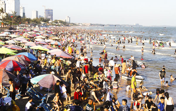 Chiều mùng 5 Tết, khách các tỉnh vẫn về tắm biển Bãi Sau đông nghẹt.          Ảnh: ĐĂNG KHOA