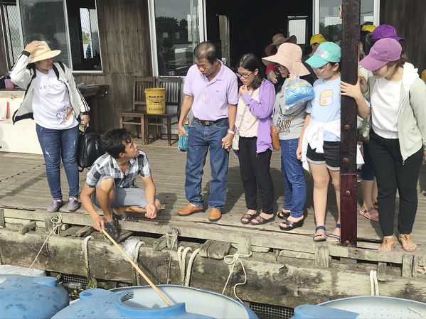 Du khách tham quan khu nuôi cá bè trên Cồn Sơn. 