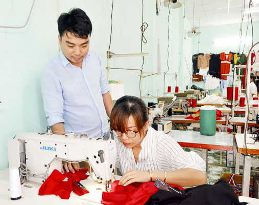 Anh Trần Duy Tuấn hướng dẫn công nhân may gia công tại xưởng may của gia đình.
