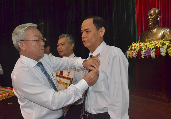 Ông Hoàng Minh Kim, Phó Bí thư Thường trực Đảng ủy Khối Cơ quan và DN tỉnh trao Huy hiệu Đảng cho các đảng viên.