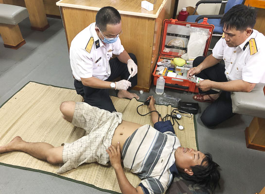 Quân y tàu 261 tiêm thuốc giảm đau tạm thời cho bệnh nhân Nguyễn Văn Nguyên. Ảnh: HUY VIÊN