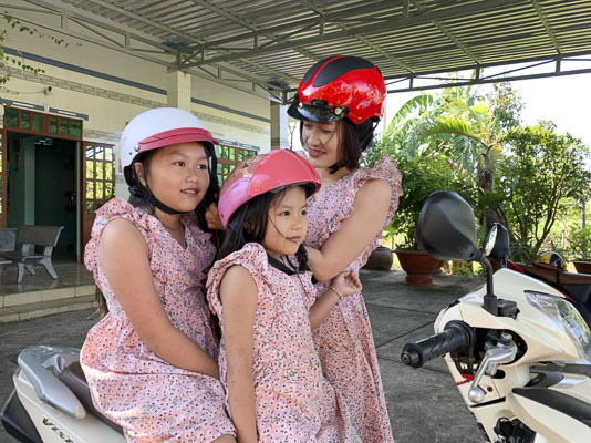 Chị Bùi Thị Bích Thảo (khu phố Thanh Long, TT.Đất Đỏ) đội mũ bảo hiểm cho con trước khi tham gia giao thông.