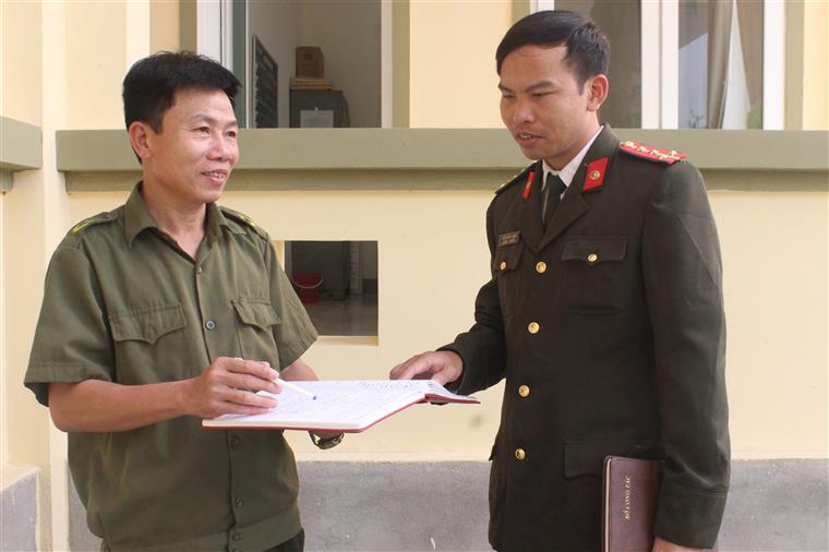 Đại úy Trần Đình Quang (phải), Công an chính quy đảm nhiệm chức danh Phó Trưởng Công an xã Hưng Long, huyện Hưng Nguyên  bàn giải pháp bảo đảm ANTT trên địa bàn