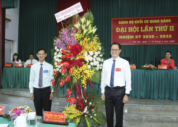 Đồng chí Nguyễn Văn Lợi (bên trái), Phó Trưởng Ban Tổ chức Tỉnh ủy tặng hoa chúc mừng Đại hội. 