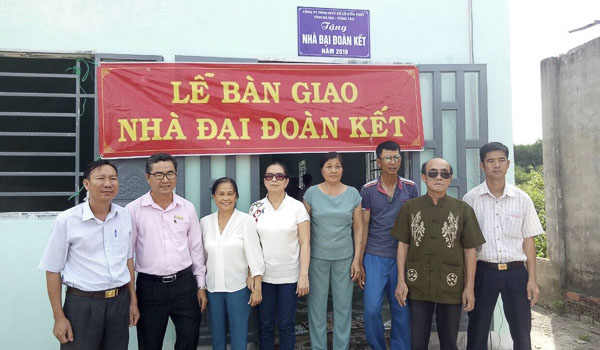 Chị Nguyễn Thị Quyến (thứ 4 từ phải qua) cùng đại diện chính quyền địa phương và nhà tài trợ trao nhà đại đoàn kết cho hội viên có hoàn cảnh khó khăn.