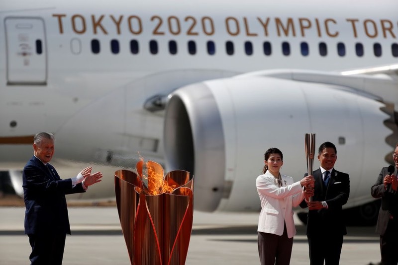 VĐV judo Nomura Tadahiro và đô vật Yoshida Saori đón ngọn đuốc để thắp vào một đài đuốc nhỏ. Nguồn: NHK