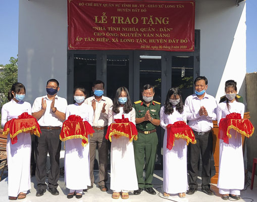 Đại diện Bộ CHQS tỉnh và chính quyền địa phương cắt băng khánh thành trong lễ trao tặng “Nhà tình nghĩa quân dân” cho gia đình ông Nguyễn Văn Năng.