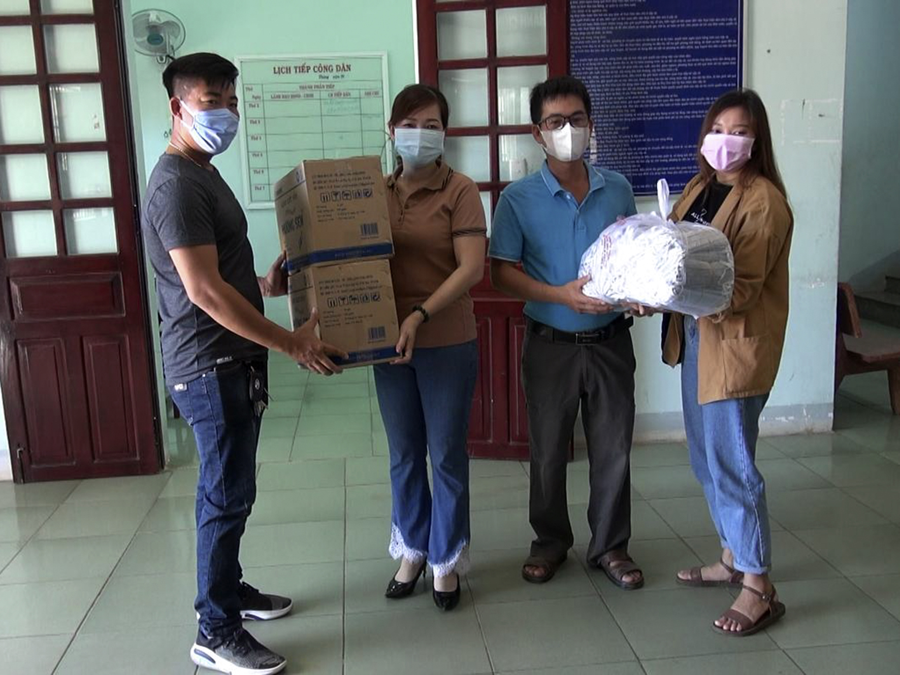 Bà Nguyễn Thị Ngọc Diệu (thứ hai từ trái qua), Phó Chủ tịch UBND xã Bình Châu nhận 500 khẩu trang y tế và 2 thùng gạo lứt rong biển sấy của Công ty TNHH Đầu tư Giáo dục Đất Rồng.