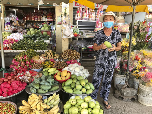 Bà Nguyễn Thị Lợi, chủ sạp bán trái cây, hoa tươi có gần 50 năm buôn bán tại chợ.