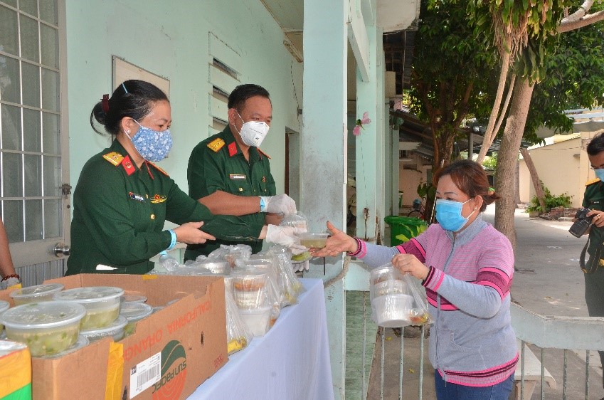 Cán bộ, chiến sĩ Bộ CHQS tỉnh phát cơm cho bệnh nhân nghèo tại Bệnh viện Lê Lợi.