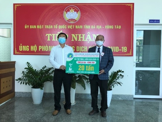 Ông Simon Trần, cố vấn đặc biệt Công ty CP Đại Nam Ong Biển trao bảng tượng trưng ủng hộ 20 tấn gạo thông qua UBMTTQVN tỉnh.