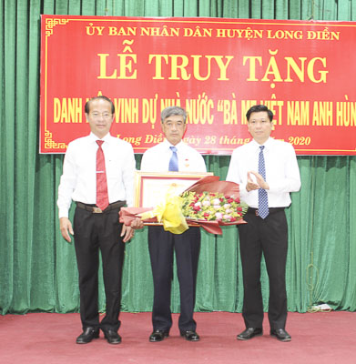 Thừa ủy quyền của Chủ tịch nước, ông Trần Văn Tuấn, Phó Chủ tịch UBND tỉnh ( bìa phải) trao danh hiệu Bà mẹ Việt Nam Anh hùng cho thân nhân mẹ Nguyễn Thị Sáu.