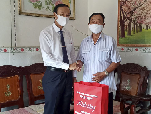 Ông Nguyễn Văn Thọ, Chủ tịch UBND tỉnh tặng quà ông Lê Hà,  nguyên thuyền trưởng tàu không số. Ảnh: ĐÔNG HIẾU