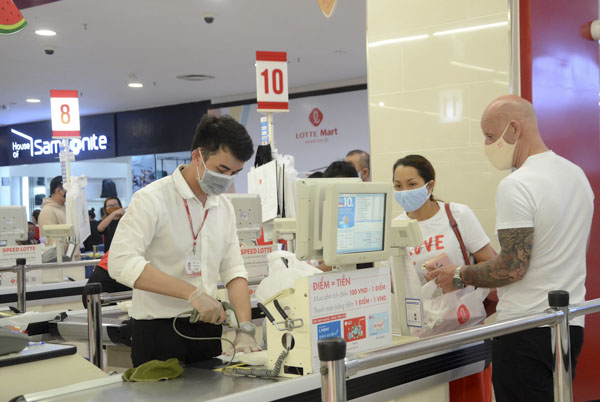 Mọi người dân và du khách, kể cả khách nước ngoài khi vào siêu thị mua sắm đều phải đeo khẩu trang. Trong ảnh: Nhân viên siêu thị Lotte Mart Vũng Tàu thanh toán tiền hàng cho khách sáng 30/4.