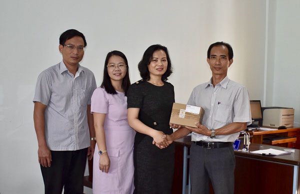 Bà Huỳnh Thị Phúc (thứ 3 từ trái qua), Phó Chủ tịch LĐLĐ  tỉnh trao tặng chuột máy tính cho Ban Giám hiệu Trường THPT Hòa Hội.