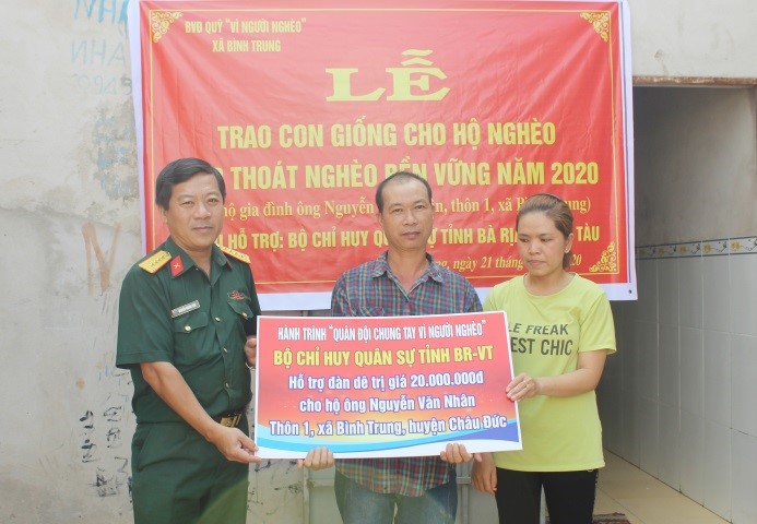Đại tá Nguyễn Hoàng Tấn, Phó Chính ủy Bộ CHQS tỉnh trao Biểu trưng hỗ trợ 5 con dê giống cho hộ gia đình  ông Nguyễn Văn Nhân.