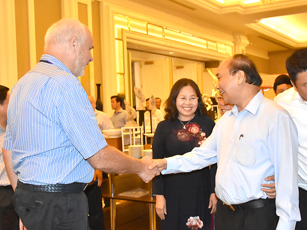 Thủ tướng Chính phủ Nguyễn Xuân Phúc bắt tay trao đổi với DN nước ngoài bên lề hội nghị.
