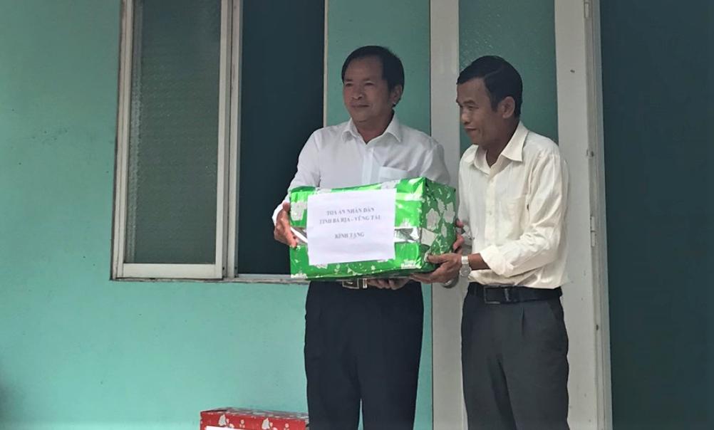 : Ông Trần Văn Vui (bên trái), Phó Chánh án TAND tỉnh BR-VT trao quà cho con trai bà Hồ Thị Anh, chia sẻ niềm vui có nhà mới.