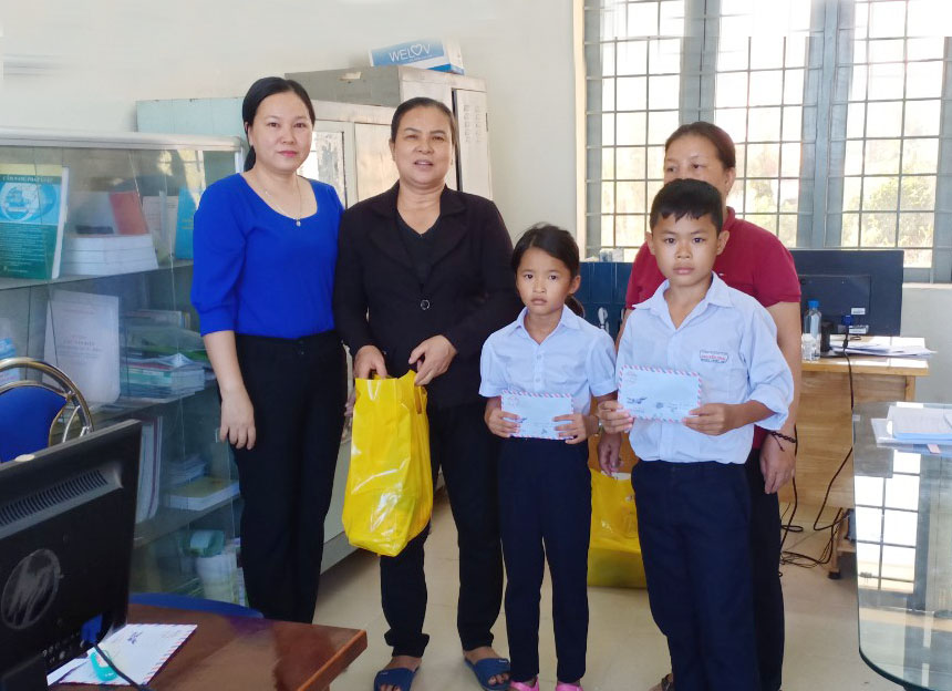 Bà Đỗ Thị Ngọc Tiên (trái), Chủ tịch Hội LHPN xã Phước Hưng trao học bổng  “Tiếp sức cùng em đến trường” cho HS nghèo.