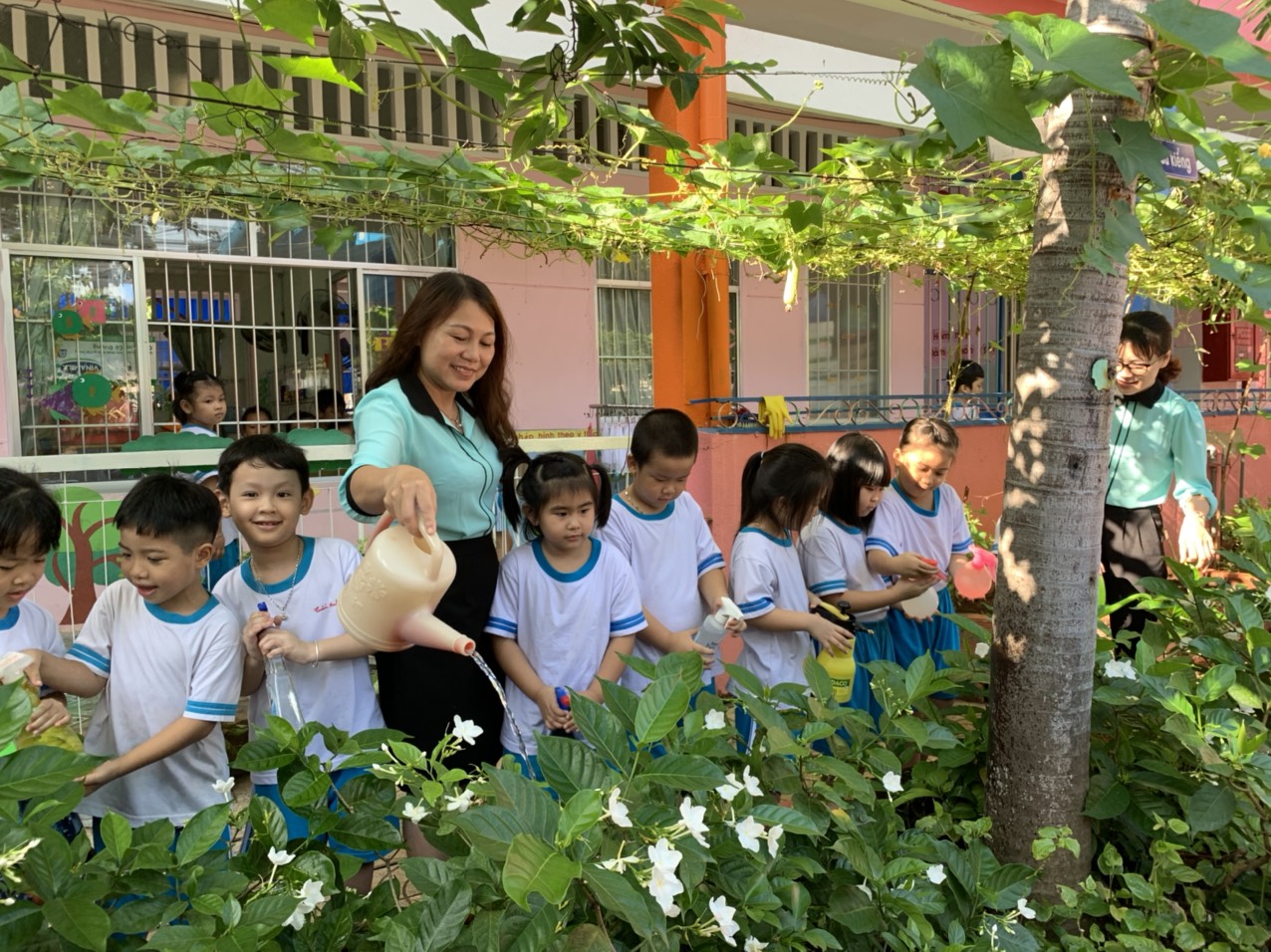 Cô Nguyễn Thị Phương, Hiệu trưởng Trường MN Ánh Dương cùng HS chăm sóc cây xanh trong trường.