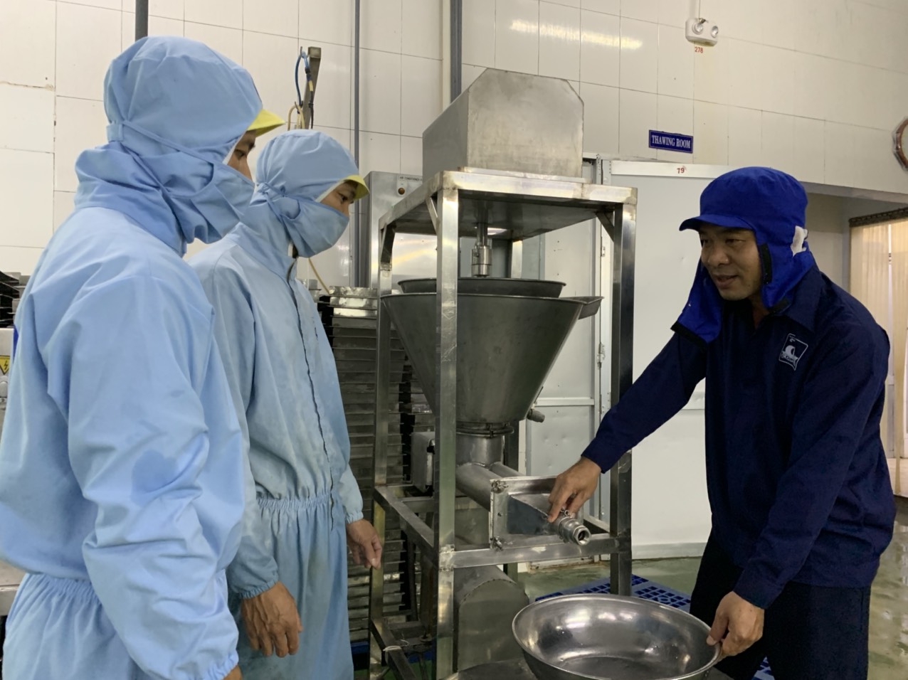 Anh Mã Thành Phương hướng dẫn công nhân sử dụng máy “Cải tiến, chế tạo máy bơm định lượng sản phẩm phối trộn giữa surimi với các loại rau củ”.