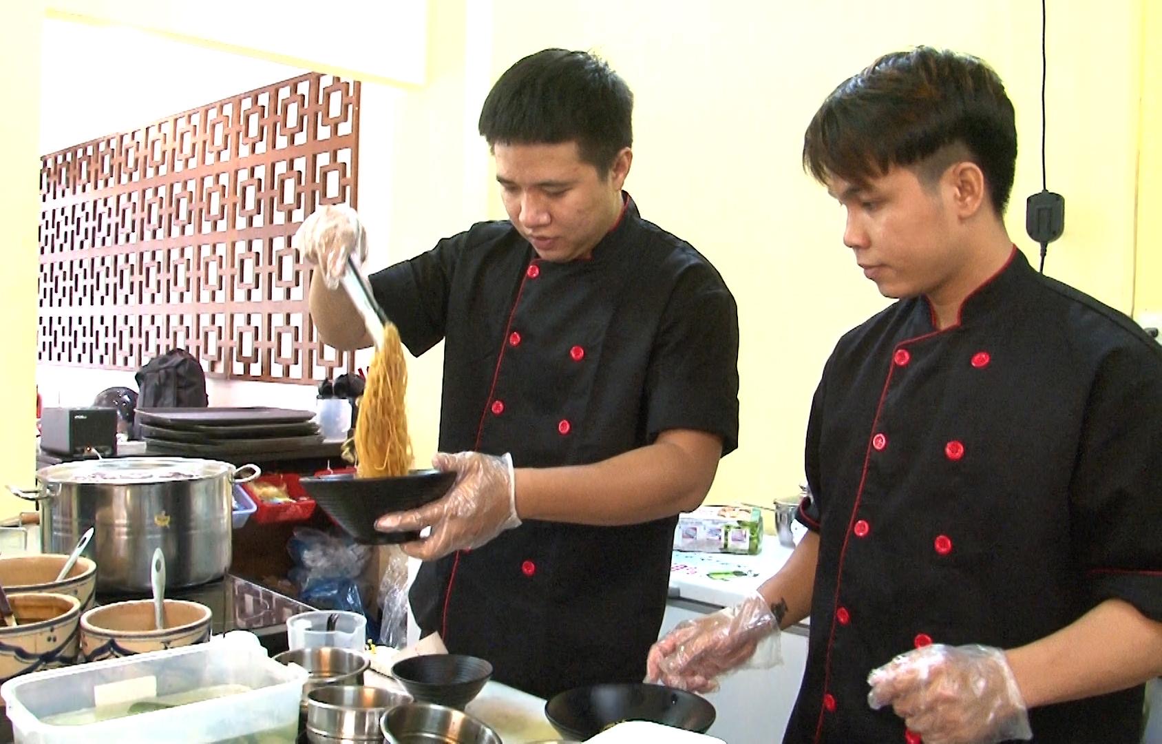 Anh Lê Quốc Việt Hoàng hướng dẫn nhân viên chế biến món mì hoành thánh xá xíu.