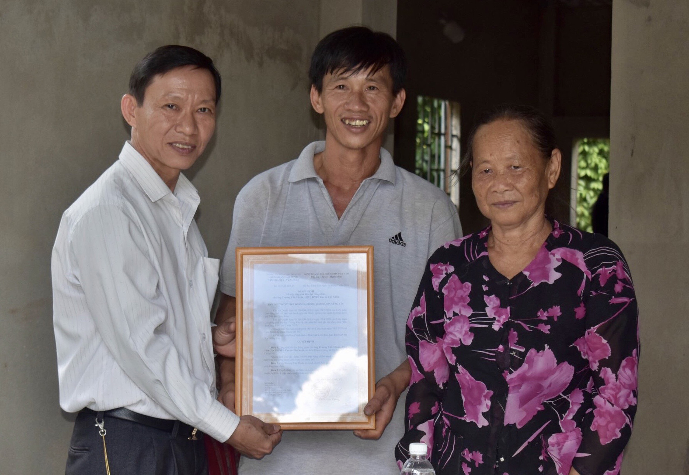 Ông Nguyễn Châu Trinh, Phó Chủ tịch LĐLĐ tỉnh trao Quyết định bàn giao nhà cho gia đình anh Trương Văn Thuận.