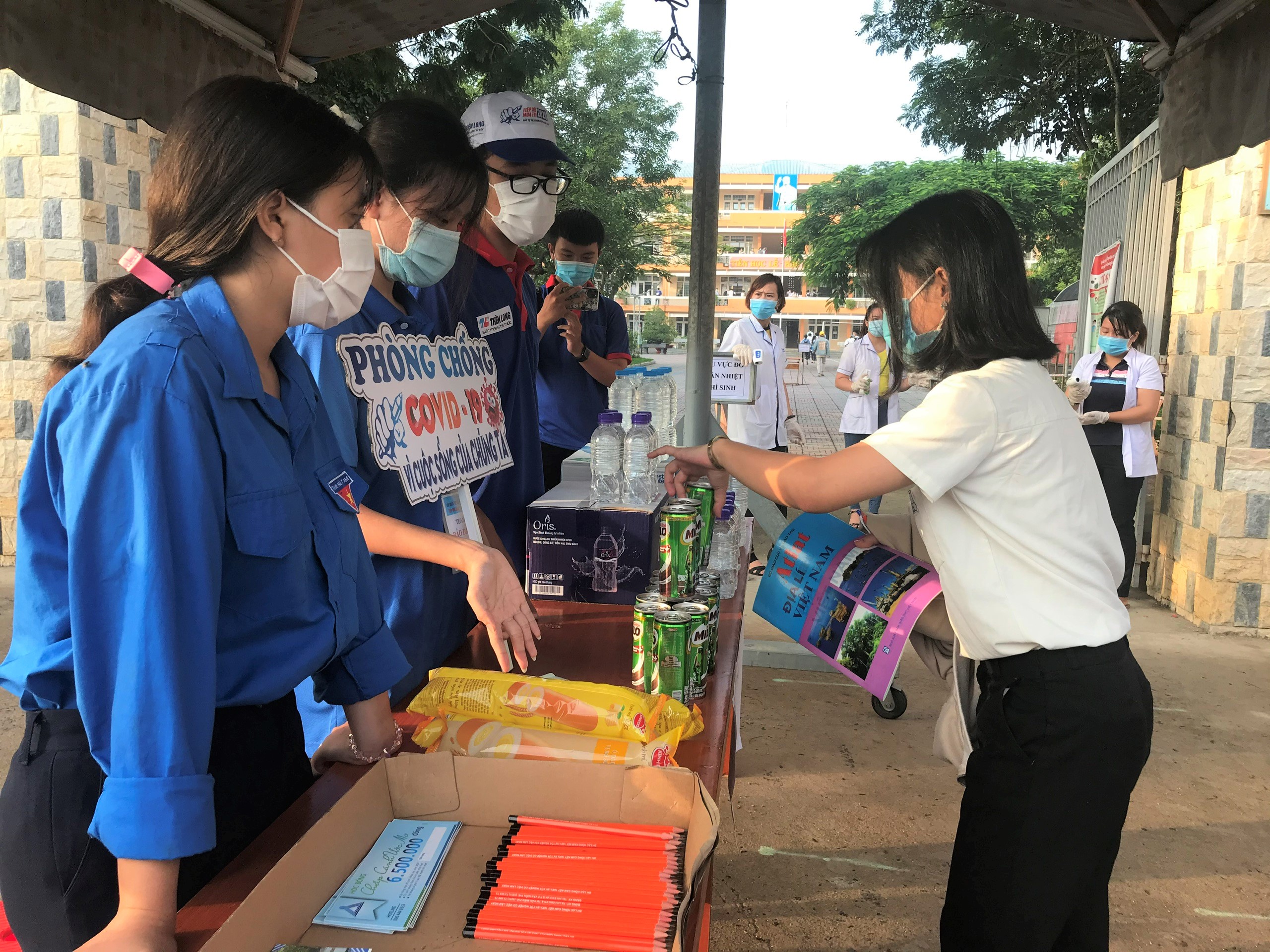 Tình nguyện viên phát nước uống miễn phí cho TS dự thi tại điểm thi Trường THPT Phú Mỹ.