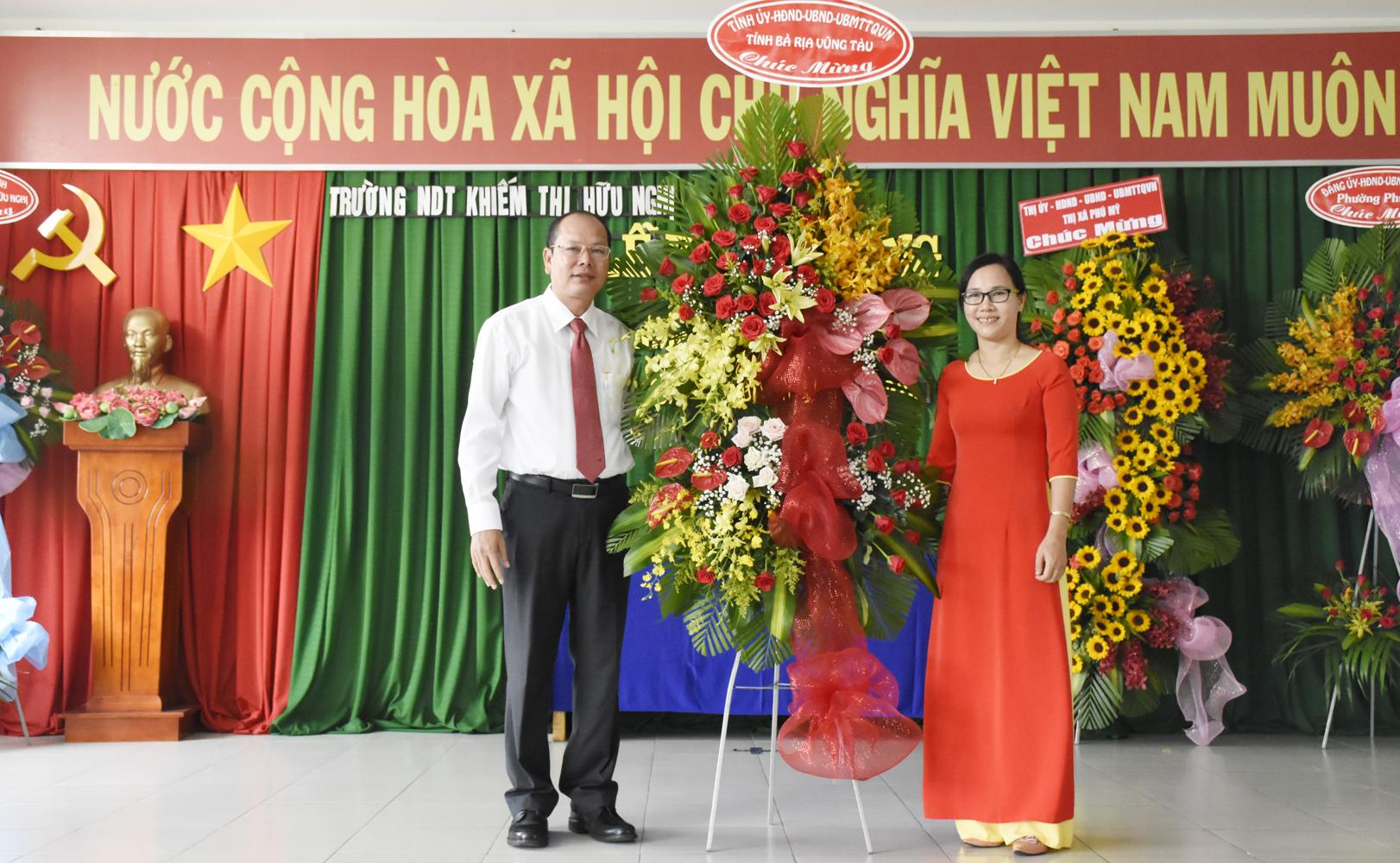 Ông Nguyễn Văn Hải, Giám đốc Sở TNMT tặng hoa chúc mừng thầy và trò Trường Nuôi dạy trẻ Khiếm thị Hữu Nghị. Ảnh: MỸ LƯƠNG