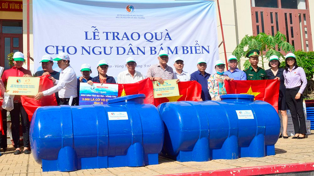 Đại diện Báo Tài nguyên và Môi trường, Báo Người Lao động trao tặng bồn chứa nước ngọt và cờ Tổ quốc cho ngư dân TP.Vũng Tàu.