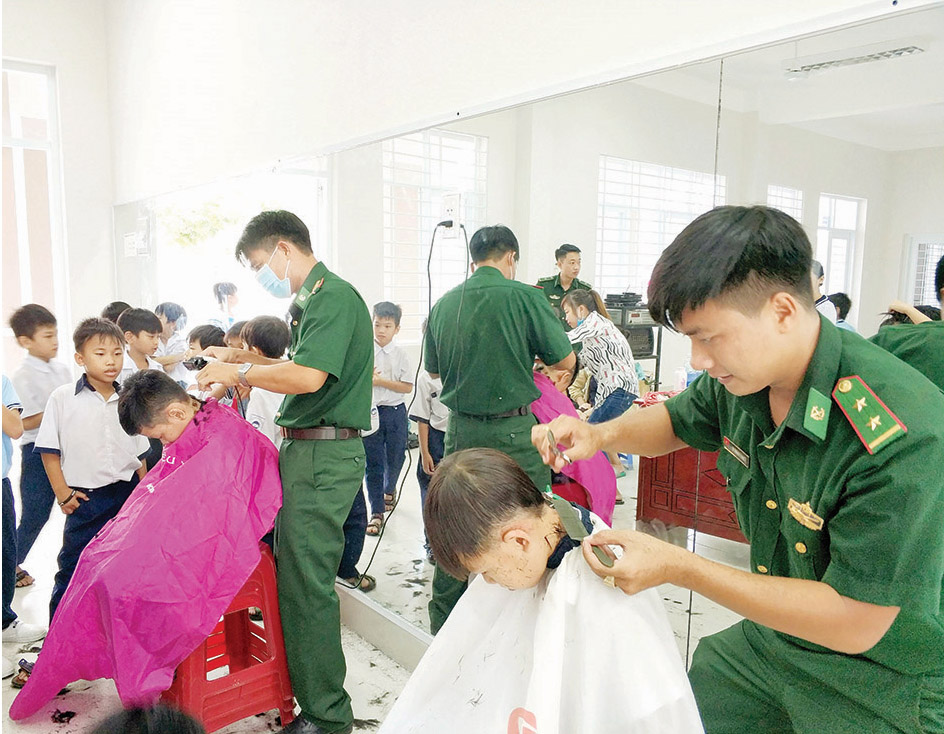 Cán bộ, chiến sĩ Đồn Biên phòng Phước Tỉnh cắt tóc miễn phí cho HS Trường TH Lê Hồng Phong, huyện Long Điền trong chương trình  “Tay kéo Biên phòng”.