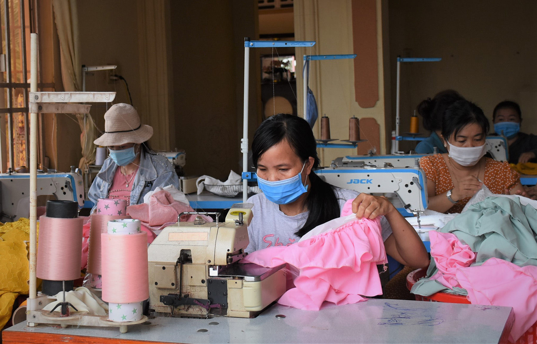 Chị em hăng say làm việc tại cơ sở may gia công quần áo trẻ em của bà Nguyễn Thị Thúy Oanh (ấp 2 Đông, xã Bàu Lâm). 