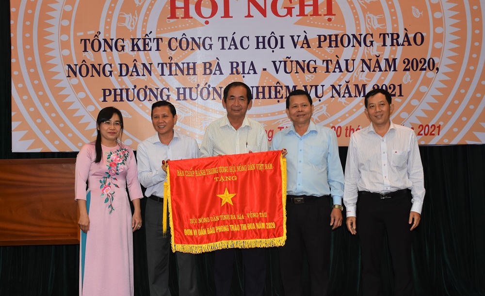 Ông Phạm Minh Hùng (thứ 2 bên phải), Ủy viên Ban Thường vụ Trung ương Hội Nông dân Việt Nam - Phụ trách khu vực phía Nam trao cờ Thi đua xuất sắc năm 2020 của Hội Nông dân Việt Nam cho Hội Nông dân tỉnh.