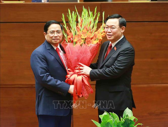 Chủ tịch Quốc hội Vương Đình Huệ tặng hoa chúc mừng Thủ tướng Phạm Minh Chính. Ảnh: Phương Hoa/TTXVN