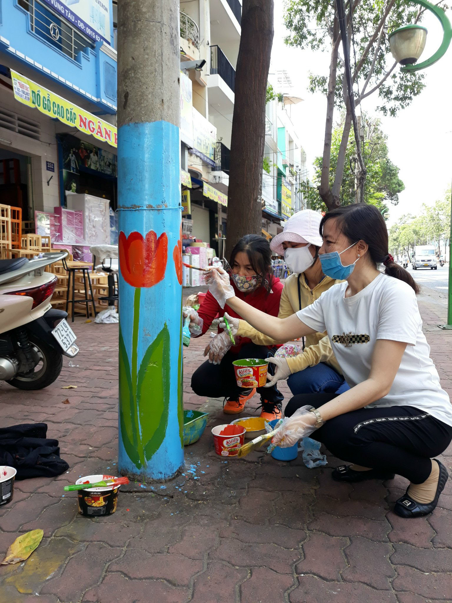 Hội viên Hội LHPN phường 4 vẽ hoa trang trí cột điện trên đường Lê Lợi.