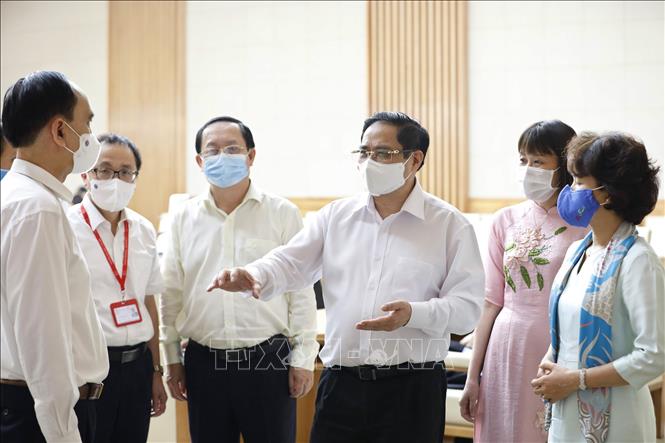 Thủ tướng Phạm Minh Chính trao đổi với đại diện các đơn vị nghiên cứu, sản xuất vaccine phòng COVID-19 trong nước. Ảnh: Dương Giang/TTXVN