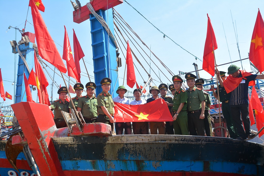 Công an Nghệ An tặng cờ cho ngư dân bám biển, vươn khơi. Ảnh: Minh Tâm