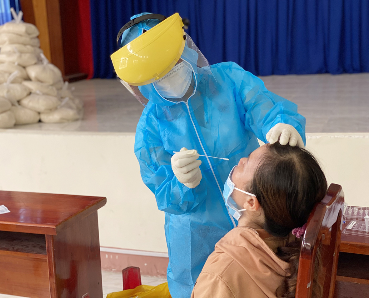 Nhân viên y tế lẫy mẫu test nhanh kháng nguyên cho người bán vé số sinh sống tại xã Tân Hải.