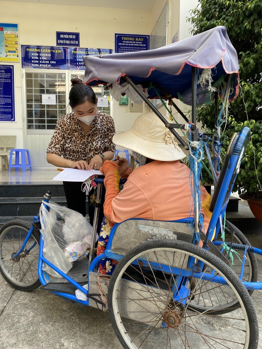 Công chức UBND phường Phước Hiệp,  TP. Bà Rịa chi trả tiền hỗ trợ cho người bán vé số trên địa bàn.