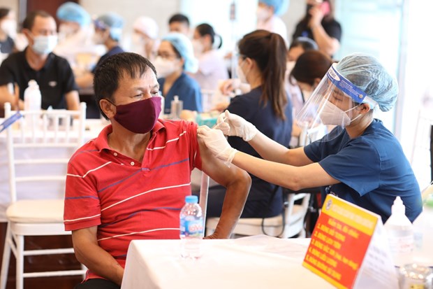Nhân viên y tế tiêm vaccine phòng COVID-19 cho người dân quận Hoàn Kiếm, TP. Hà Nội.TTXVN
