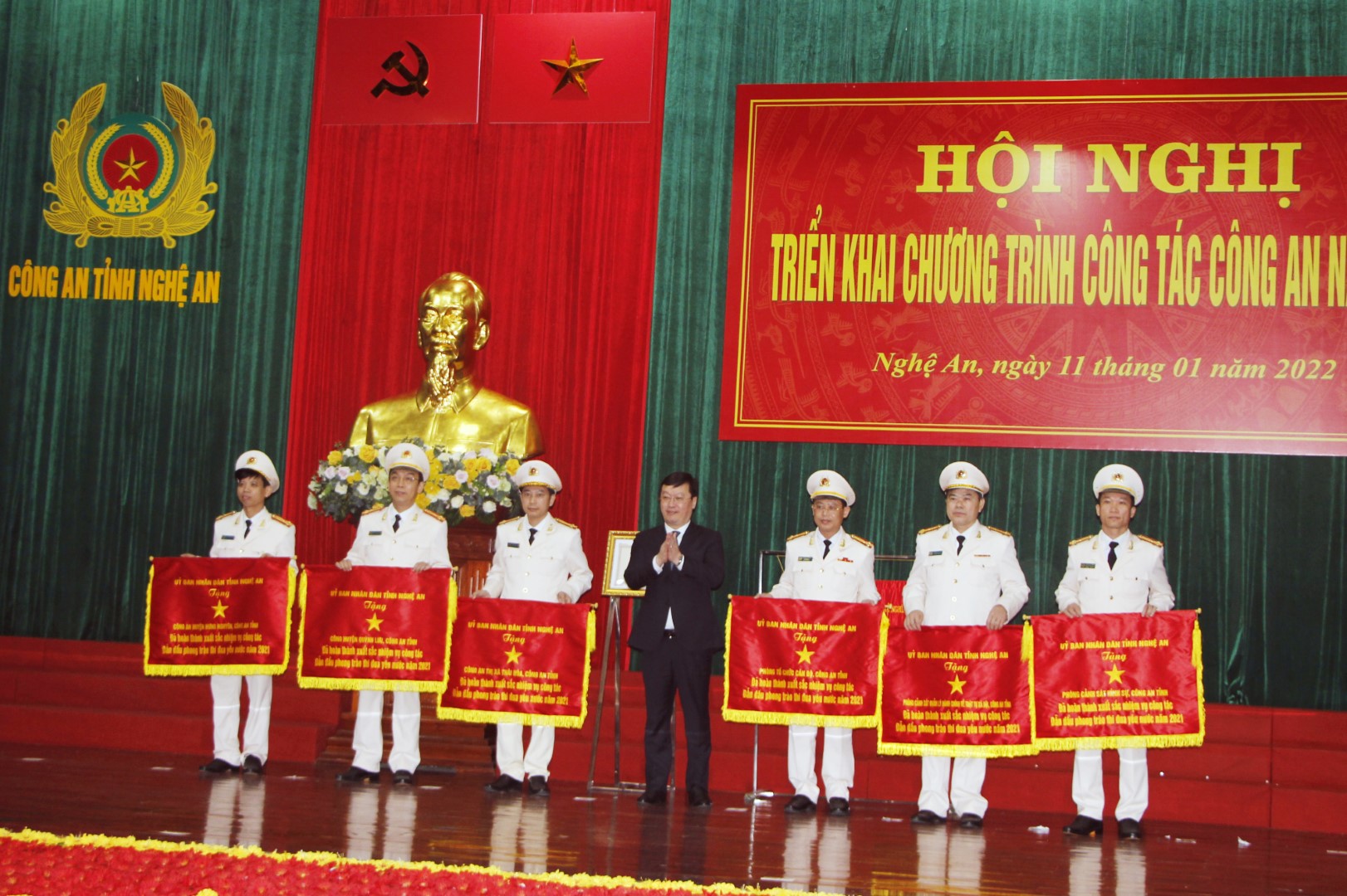 Đồng chí Nguyễn Đức Trung - Chủ tịch UBND tỉnh Nghệ An trao Cờ thi đua của UBND tỉnh cho các tập thể trong Công an Nghệ An. 