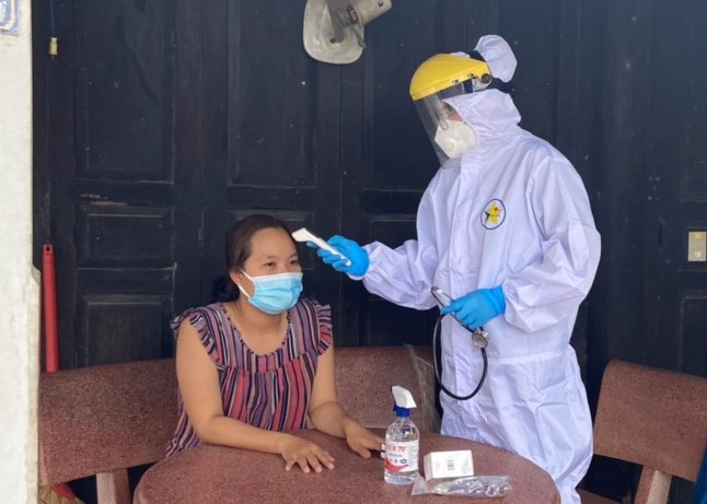 Nhân viên y tế thăm khám cho một trường hợp nhiễm COVID-19 điều trị tại nhà ở xã An Ngãi, huyện Long Điền. Ảnh: HOÀNG HƯỜNG
