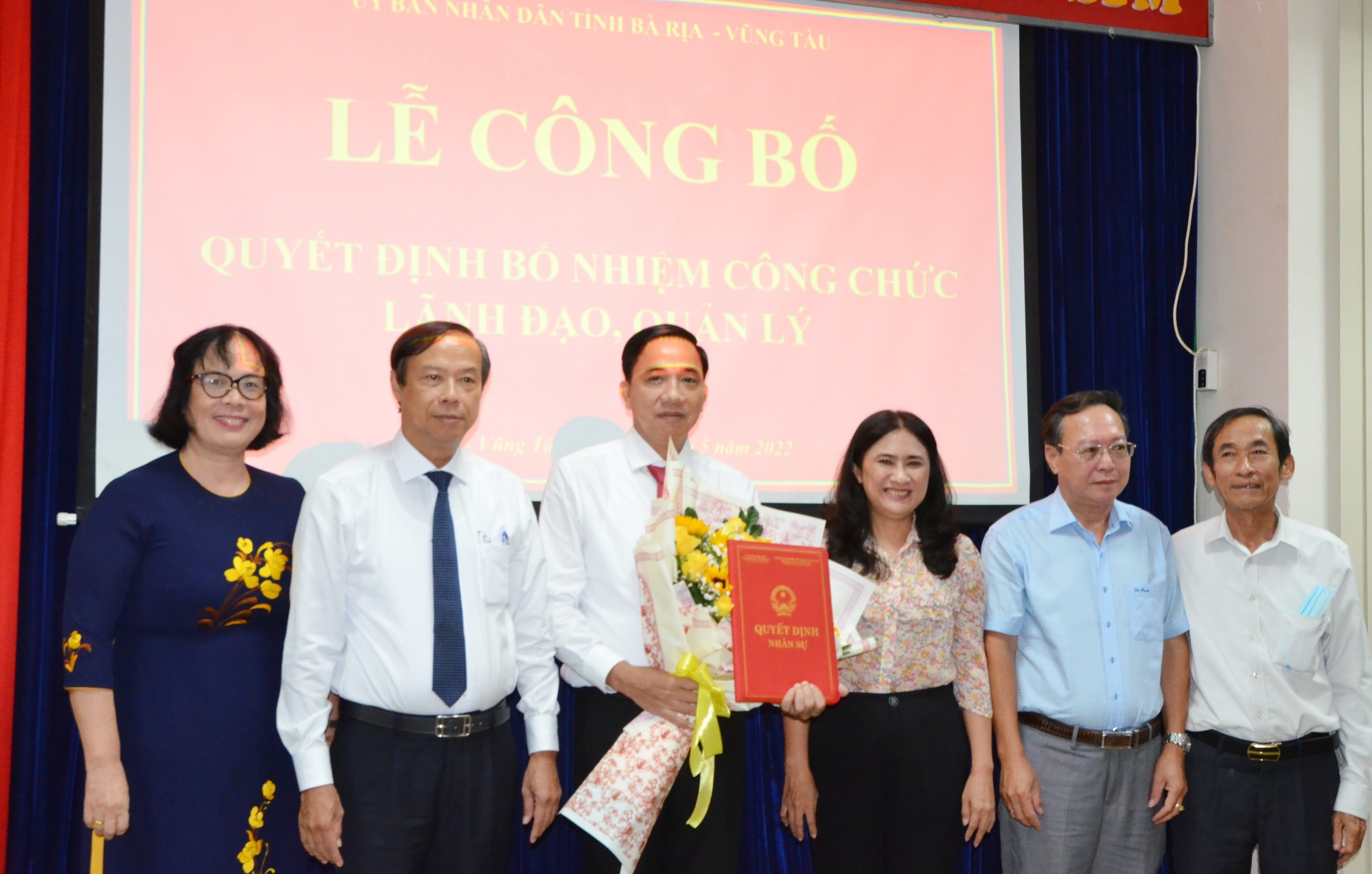 Ông Nguyễn Văn Thọ, Chủ tịch UBND tỉnh trao Quyết định và tặng hoa chúc mừng ông Trần Quốc Khánh.