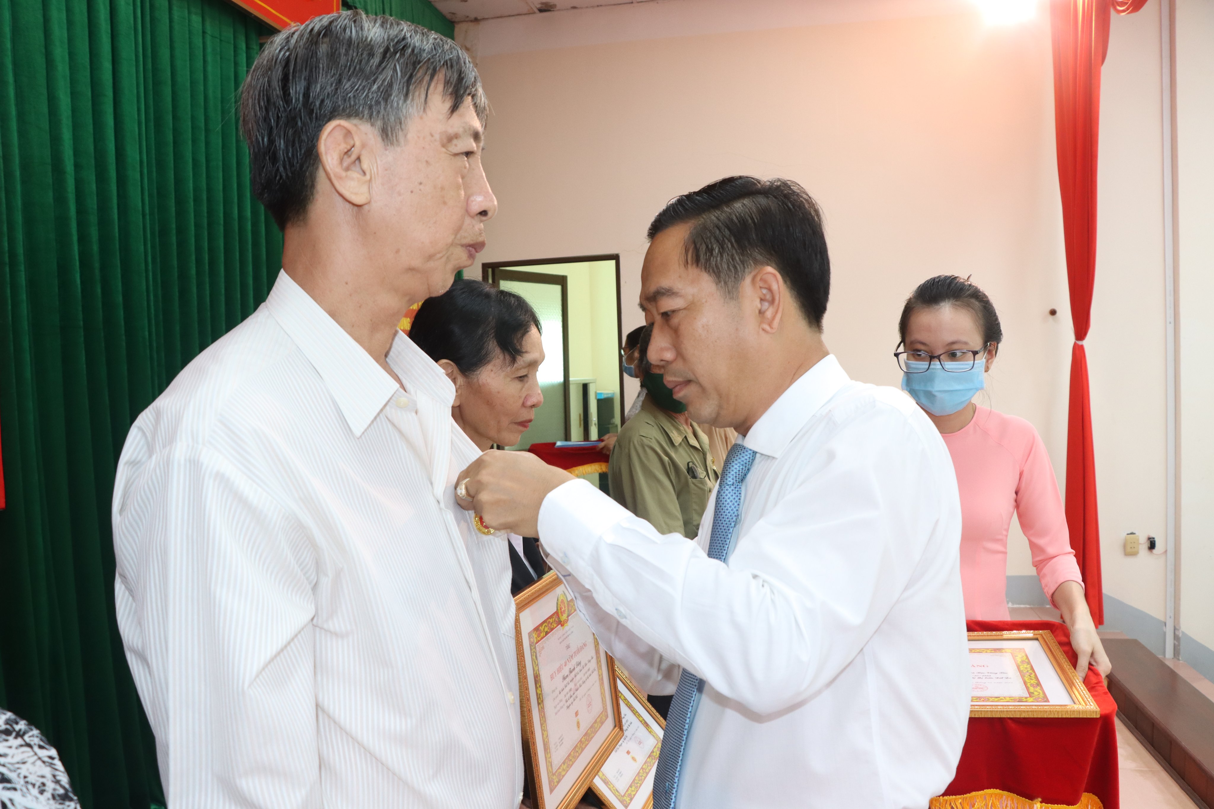 Ông Lê Văn Hòa, Bí thư Huyện ủy, Chủ tịch HĐND huyện Đất Đỏ trao Huy hiệu Đảng cho các đảng viên. Ảnh: TUẤN VŨ
