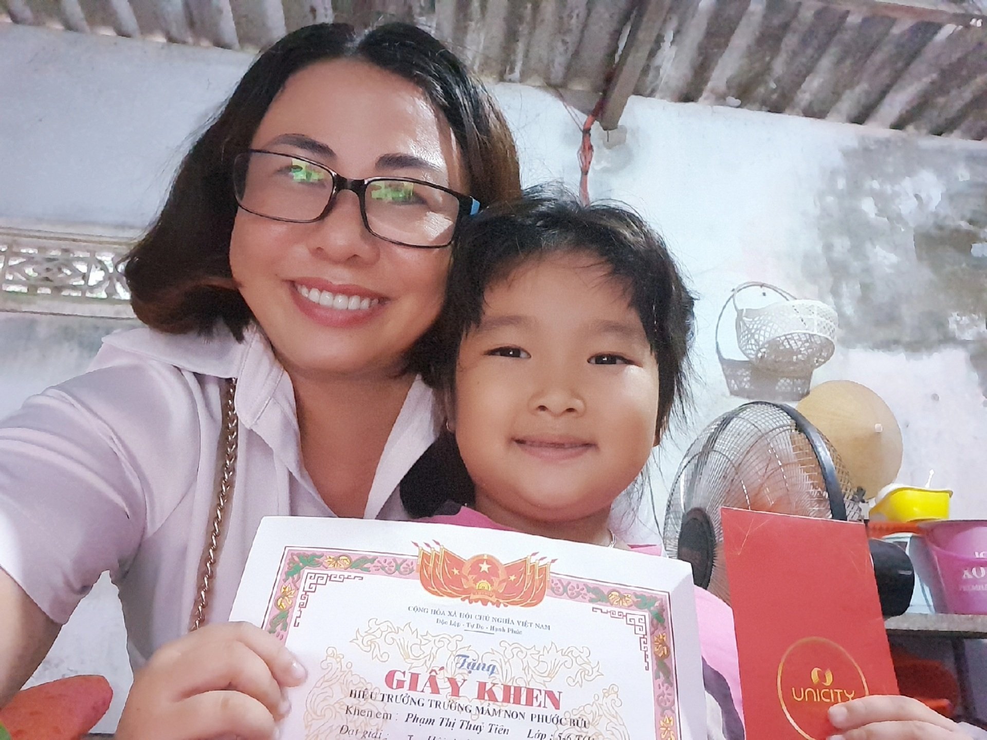 Chị Huỳnh Thị Mỹ Dung (huyện Xuyên Mộc) chụp ảnh lưu lại kỷ niệm khi đến thăm, trao tiền hỗ trợ hàng tháng và tặng SGK cho con đỡ đầu khi cháu chuẩn bị vào lớp 1.