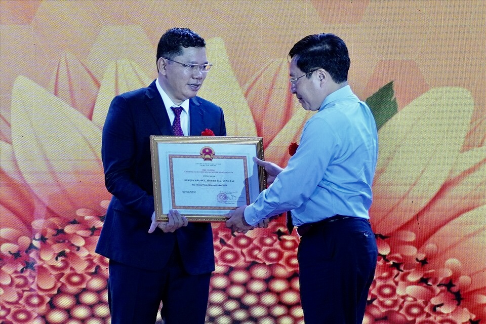 Phó Thủ tướng Thường trực Chính phủ Phạm Bình Minh (bìa phải) trao Bằng công nhận đạt chuẩn nông thôn mới cho ông Hoàng Nguyên Dinh, Chủ tịch UBND huyện Châu Đức.