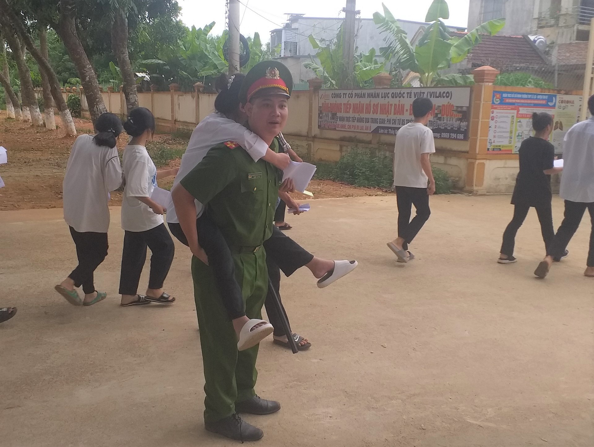 Một em học sinh bị đau chân, được cán bộ Công an hỗ trợ đến điểm thi
