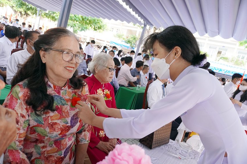 Các em HS Trường THPT Châu Thành, TP. Bà Rịa cài hoa lên áo đại biểu thể hiện sự tri ân và lòng biết ơn.