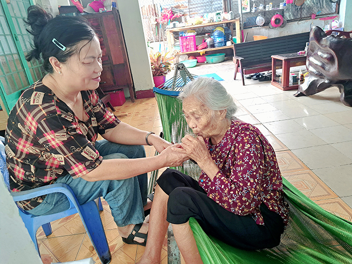 Không chỉ tận tụy với công việc được giao, bà Nguyễn Thị Nga (bìa trái) còn là người con hiếu thảo, luôn chăm sóc chu đáo mẹ già.