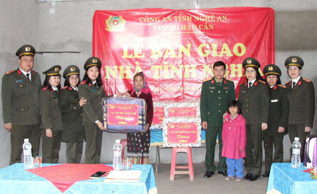 Đại diện các tổ chức đoàn thể Phòng Hậu Cần trao các vật dụng thiết yếu đến hai bà cháu Hoàng Thị Loan
